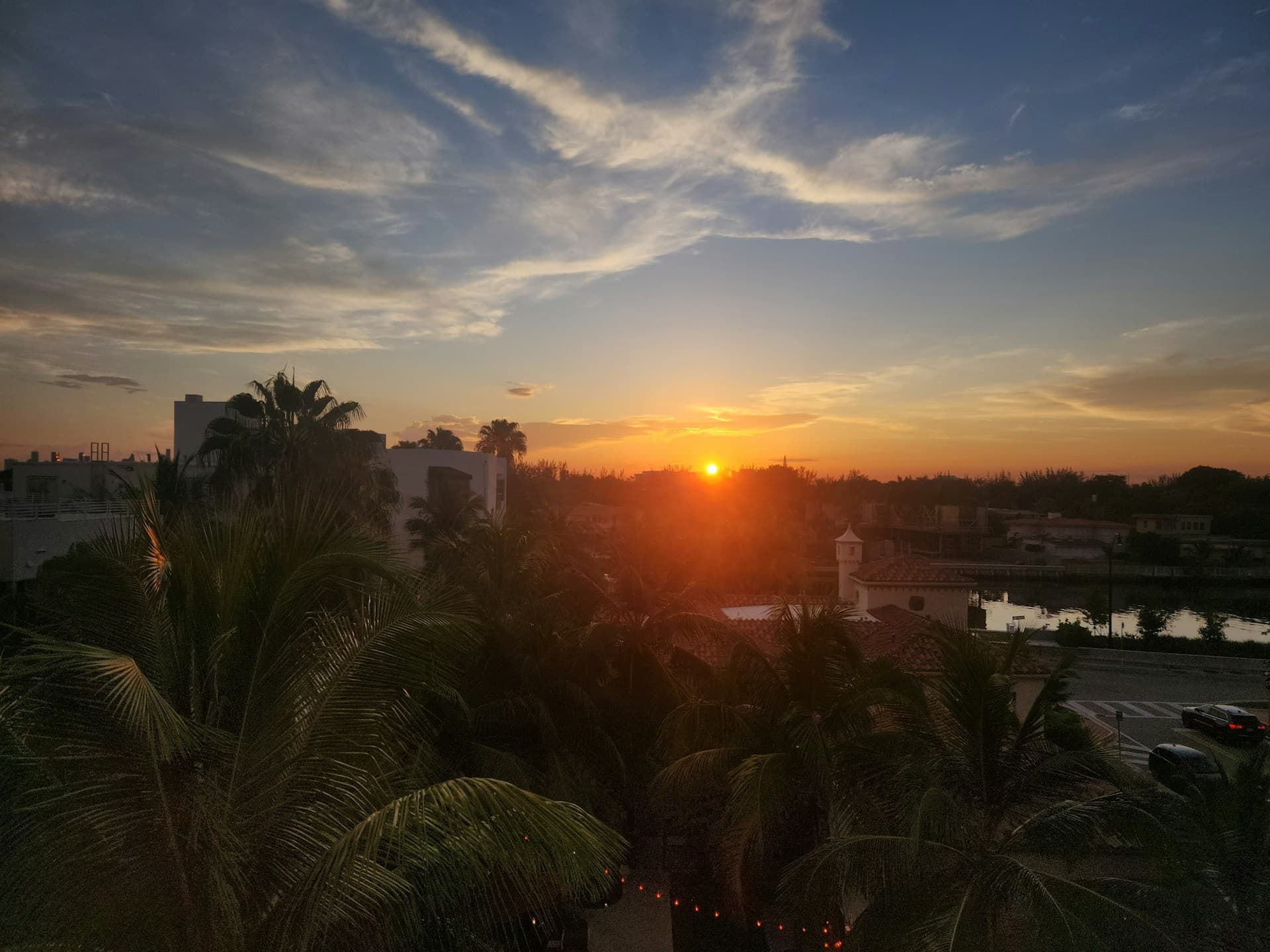 Oraș de coastă în stil Miami la apus, cu palmieri și canal